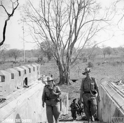 Infantry shelter beihind a smokescreen during the attack on Fort Dufferin, 10th March 1945